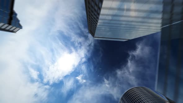 The business center camera climbs sharply upward along the mirrored high-rise buildings