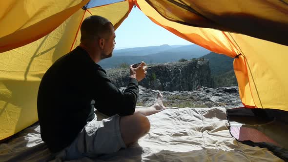 Man drinks from a mug in an camping outdoor