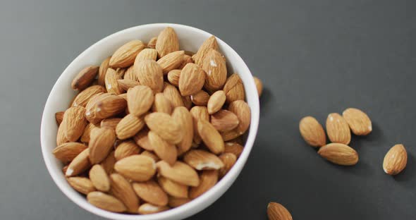 Video of fresh fruit almonds in a bowl on grey background