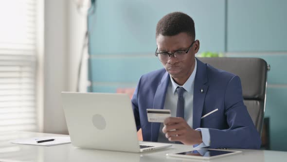 Young African Businessman Making Online Payment Failure on Laptop in Office