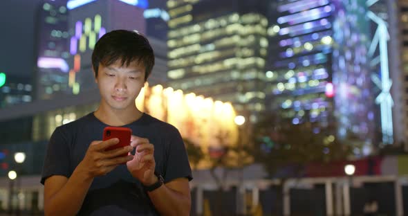 Asian Man Use Cellphone Online at Night