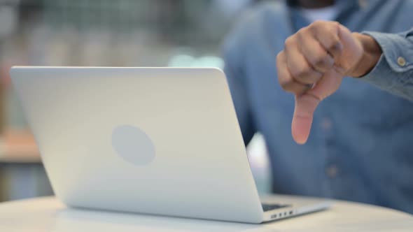 Man Working on Laptop and Showing Thumbs Down Close Up
