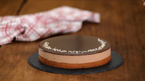 Woman Decorating And Sprinkling Nuts On Top Chocolate Mousse Cake.	