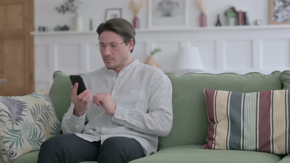 Man using Smartphone on Sofa