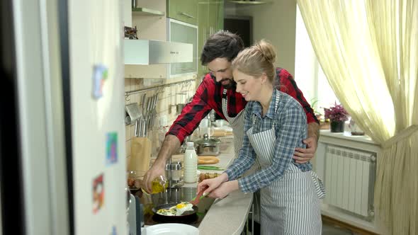 Man and Woman Frying Eggs