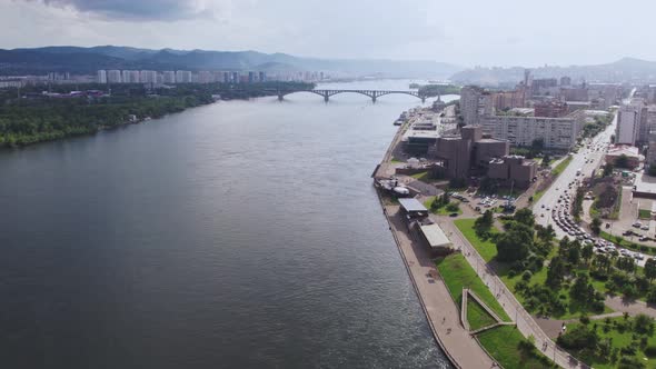 Fly Over a Wide River on a Drone Overlooking the City