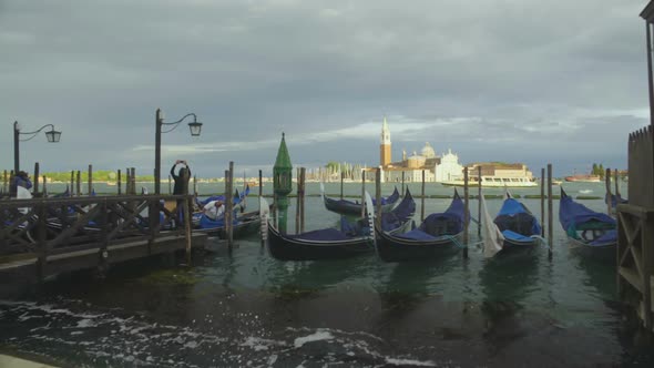 Gondolas rocking on waves of Grand Canal, tourist attraction in Venice, Italy