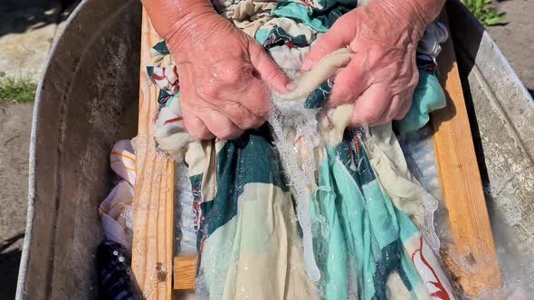 Female Hands Washing Clothes on a Washboard in Village