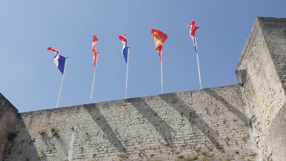 CAEN, FRANCE - JULY 2016 Famous flags of France and Normandy in city center castle slow motion  wavi