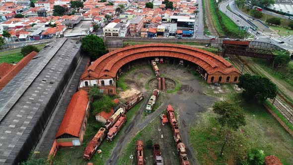 Aerial video approaching an old train station in the ciy of Campinas. There are lots of abandoned wa