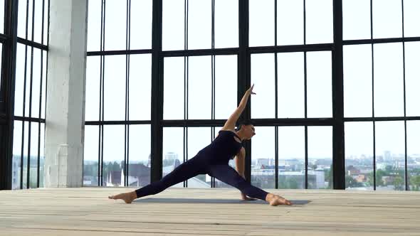 Athletic Fit Girl Stretching in Modern Studio with Big Windows