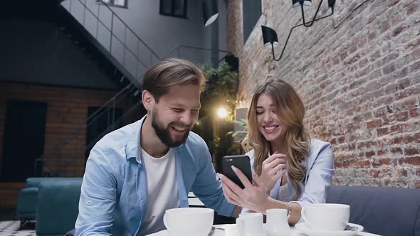 Bearded Man Sincerely Laughing with His Pretty Blond Girlfriend During Revisioning Funny Video