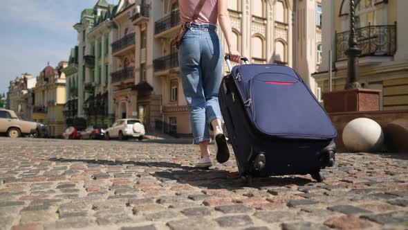 Beautiful Young Woman Tourist with Suitcase in the City Center