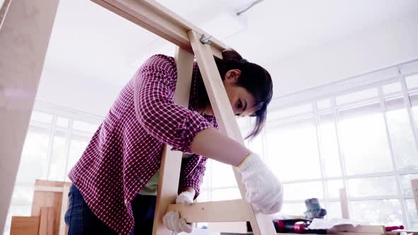 Stylish craftswoman working in carpentry. Woodwork and furniture making concept.