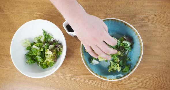 Chef Prepares Green Salad Leaves Puts Them Into Plate