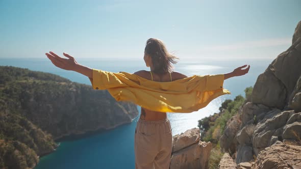 Slow Motion Rear View Freedom Filling Woman with Raising Arms Enjoying Beautiful View of Butterfly