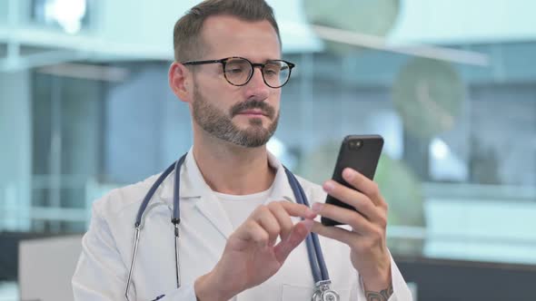 Middle Aged Male Doctor Using Smartphone