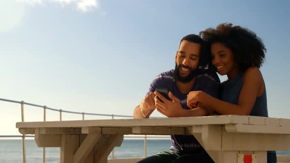 Couple using mobile phone in the beach 4k