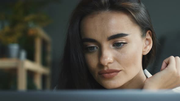 Close-up of Concentrated Woman Working on Laptop in Modern Cafe