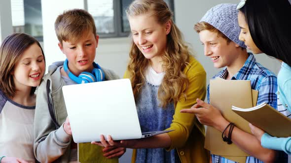 Group of students using laptop in classroom