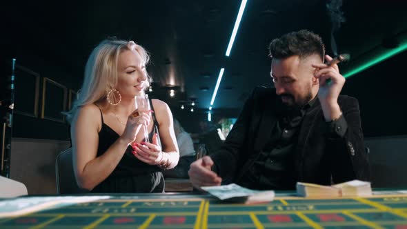 Bearded Man with Money in a Casino. Rich Businessman in Suit Is Flirting with a Beautiful Woman.