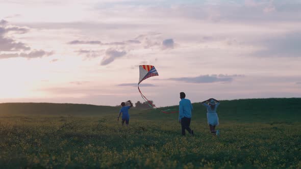 Family Outdoor Recreation a Boy with His Parents Running Through the Field and Launching a Kite