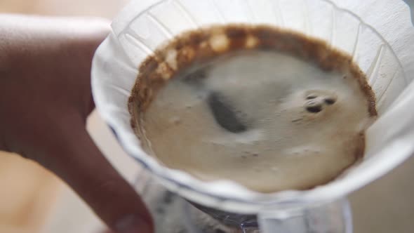 Man's Hand Swirling Coffee in V60 Pour Over Brewer for Even Extraction