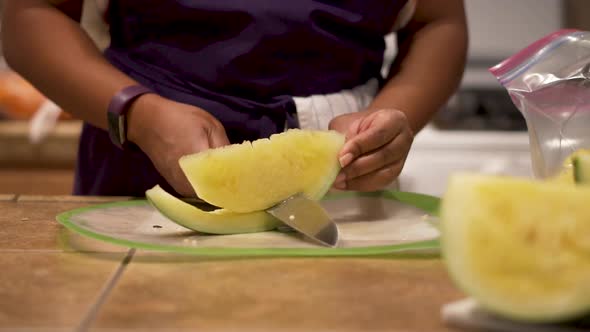 SLOWMO Closeup, cutting and removing rind from juicy yellow watermelon