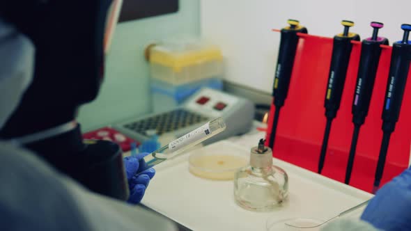 One Worker in Protective Suit Works in Laboratory