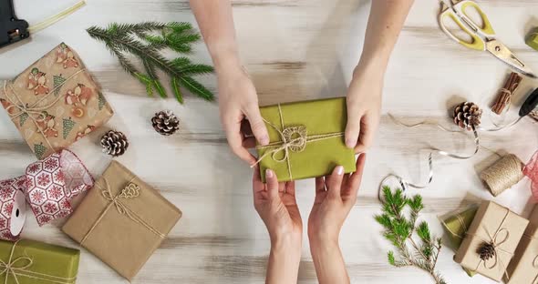 Top View, the Camera Slowly Moves Over Wooden Table, on Which Christmas Decorations, Gifts