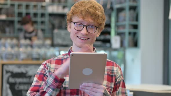 Online Video Call on Tablet By Young Redhead Man 