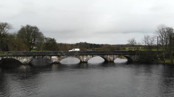 Aerial - Over the river with bridge road for car passing through. Small town of Jamestown, Ireland,