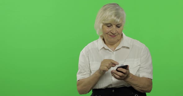 An Elderly Woman Adjusts Her Clothes and Smiles. Chroma Key