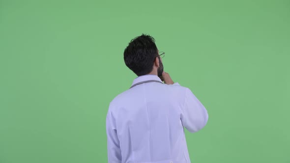 Profile View of Young Bearded Persian Man Doctor Pointing Finger