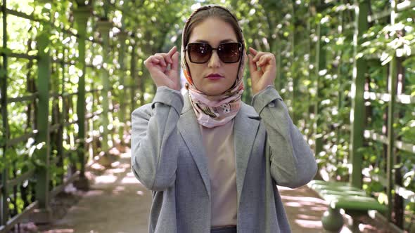 Young Woman in Headscarf Takes Off Sunglasses and Smiles