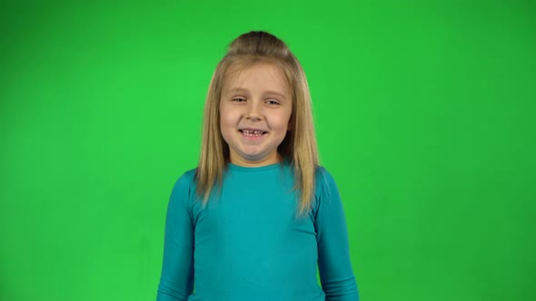 Portrait of Little Girl Posing Playfully on Green Background. 