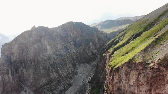 Big Brown Sharp Cliffs with Grass on Top and River in Canyon