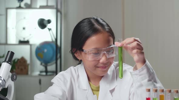 Young Scientist Girl Looking At Liquid In Test Tube