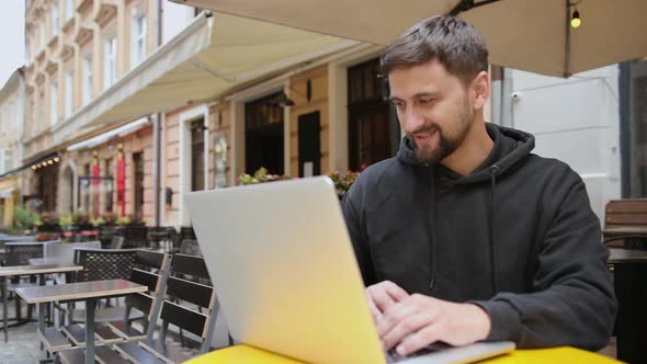 Bearded Man Working Remotely Outdoors with Laptop