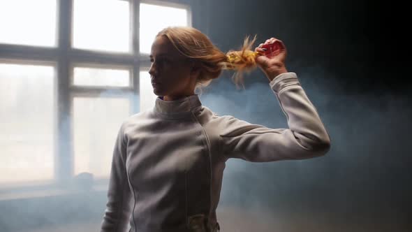 A Young Woman Fencer She Lets Her Hair Down and Shakes Her Head Down and Back