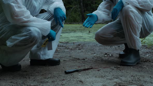 Criminalists Marking Knife at Crime Scene Closeup