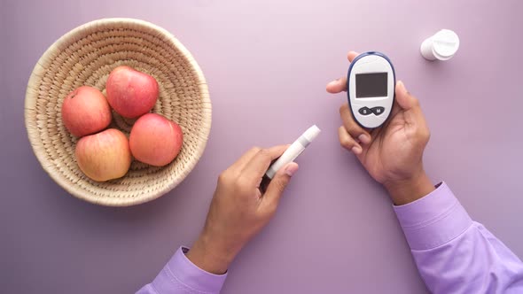 Man's Hand Measuring Blood Sugar Level