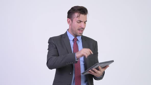 Young Happy Hispanic Businessman Using Digital Tablet and Getting Good News