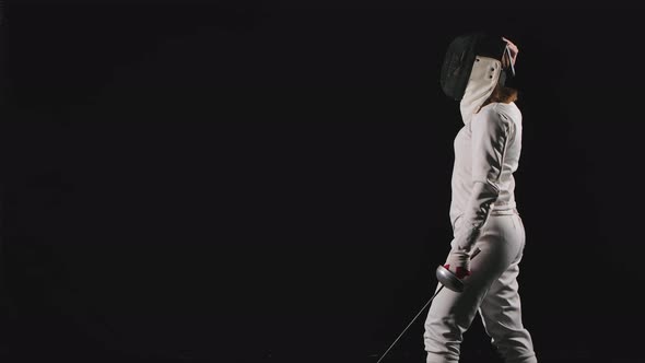 Side View of a Young Woman a Fencing Athlete Who Puts on a Mask, Lunges Forward and Gets Into a