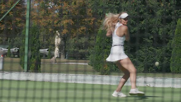 Slow Motion Female Professional Tennis Player Hits the Ball with a Racket Practice Game on the