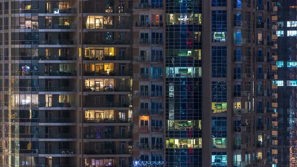 Glowing Windows in Multistory Modern Glass Residential Building Light Up at Night Timelapse