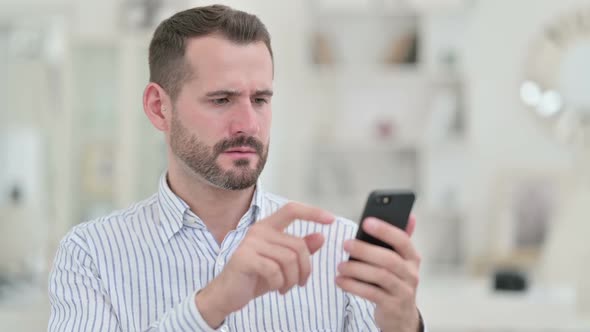 Portrait of Upset Young Man Having Loss on Smartphone