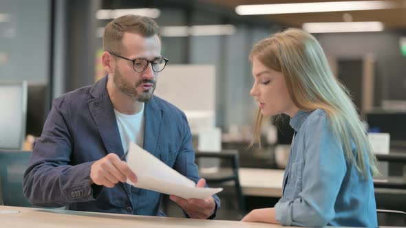 Middle Aged Businessman and Businesswoman Having Argument in Office