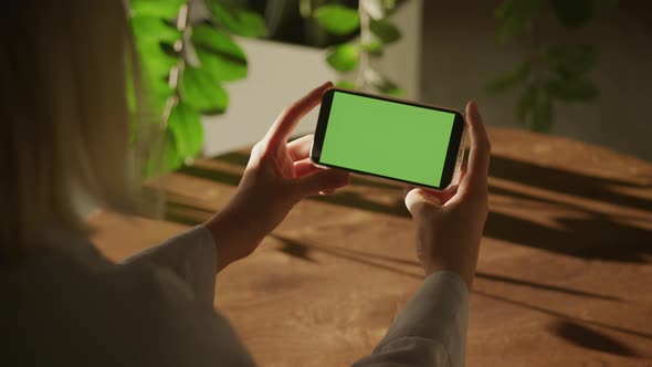 Handheld Close Up Woman Holding Horizontal Smart Phone Watching Green Screen Chroma Key