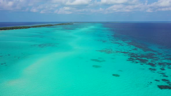 Wide flying travel shot of a sandy white paradise beach and blue water background in best quality 